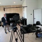 Mosaic Media Films crew filming a corporate interview with a teleprompter, boom mic and on-set monitoring